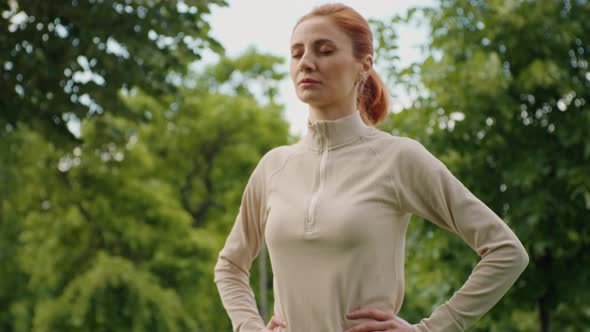 Woman in sportswear, doing breathing exercises.