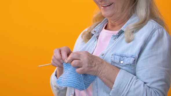 Grey-Haired Grandmother Knitting on Yellow Background, Craft Hobby, Retirement