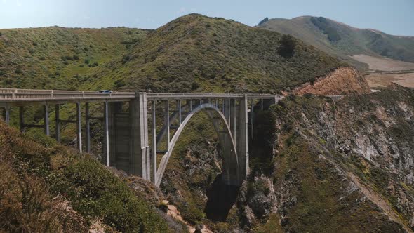 Scenic Wide Background Shot of Cars Moving Through Iconic Bixby Creek Bridge Over Highway 1