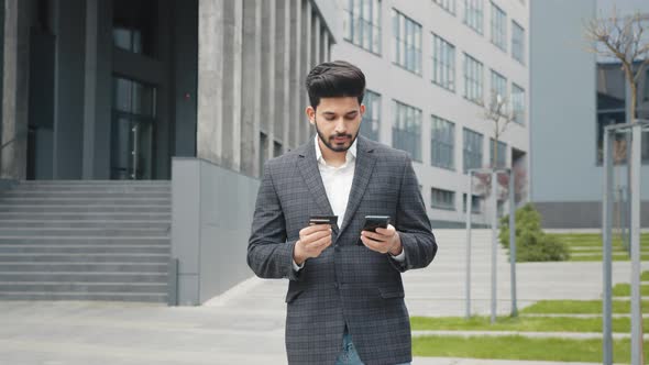 Handsome Hindu Man in Stylish Formal Clothes Using Modern Smartphone and Credit