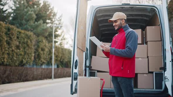 Young Man Using Tablet to View Information About the Parcel