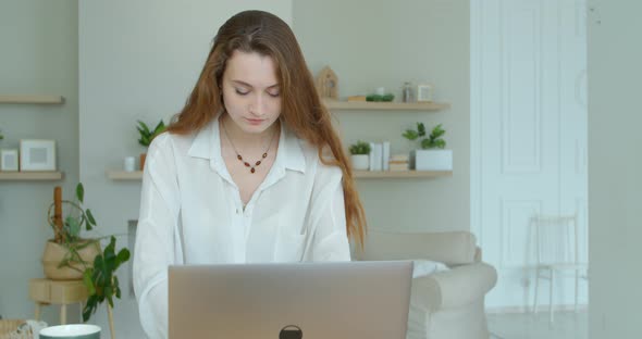 Serious Young Woman Freelancer Working on Freelance From Home Typing Email on Laptop, Focused Girl