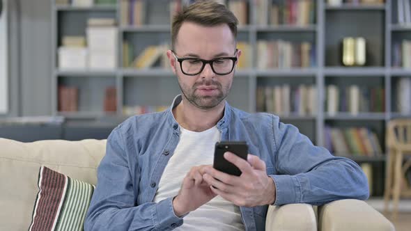 Portrait of Young Man Reacting To Failure Using Smartphone