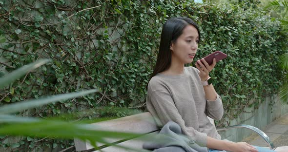 Woman work on mobile phone in city park