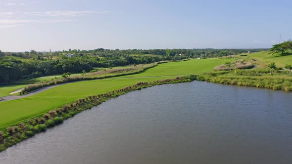 Aerial backwards shot of Vistas Golf CLub with natural lake during sunny day in Santo Domingo