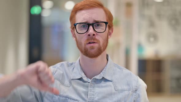 Disappointed Young Redhead Man Doing Thumbs Down