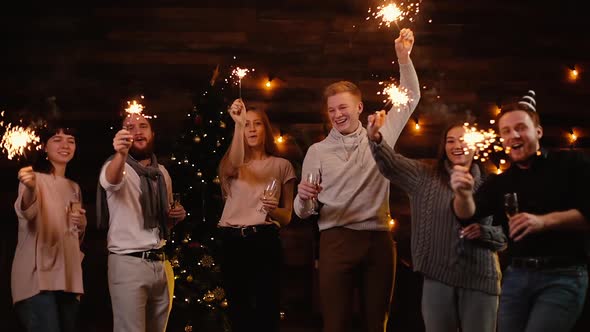 Group of Young Cheerful Friends Dance with Bengali Lights