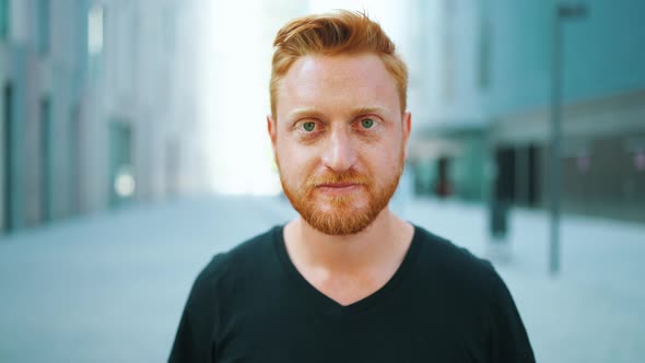 Happy red haired man looking at the camera