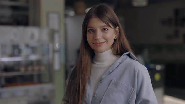 Pleasant Woman Standing at Own Cafe and Smiling on Camera