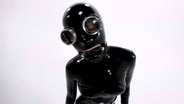 A Woman Dressed in a Tight Black Latex Suit for a BDSM Roleplaying Game She Poses and Holds Her Head