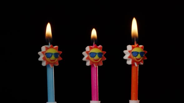 Birthday Festive Candles in Form of Sun in Sunglasses Turning Spinning Isolated on Black Background