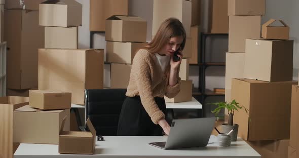 Woman Is Negotiating By Phone in Warehouse Delivery Company Business Lady Is Standing in Room with