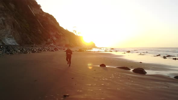 People running on a scenic sand beach at sunrise during a fitness workout in Santa Barbara, Californ