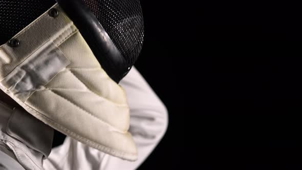 Side View of Young Woman Fencer Puts Protective Sports Mask Helmet