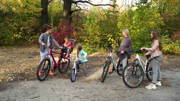 Family Standing with Bicycles in Park After Cycle Ride