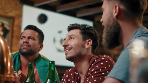 Three men watching soccer game in the pub