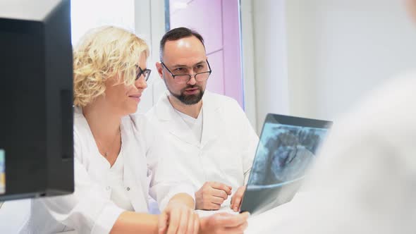 Dentists looking at x-ray image and discussing
