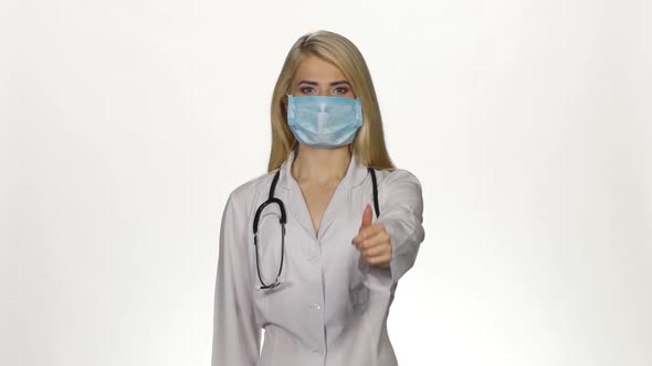 Female Doctor Making Thumbs Up Sign. White