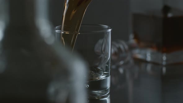 Whisky is poured into glass in slow motion; shot on Phantom Flex 4K at 1000 fps alt