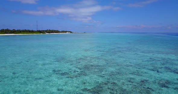 Daytime flying abstract view of a white sandy paradise beach and blue water background in hi res 4K