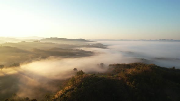 4K Aerial view from drone over mountains fog. Golden scenery at sunrise, Nan, Thailand