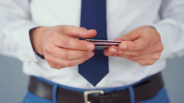 Formally Dressed Man Selects a Credit Card From Several