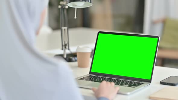Rear View of Arab Woman Working on Laptop with Chroma Key Screen