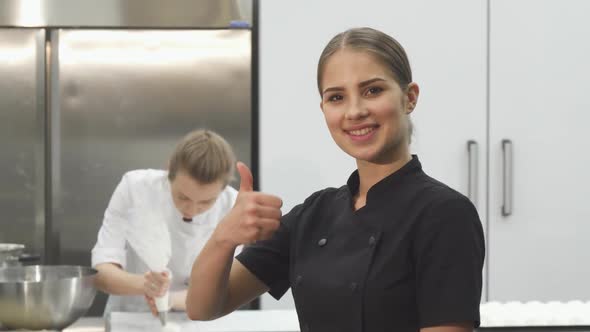 Happy Female Chef Smiling Showing Thumbs up at the Kitchen