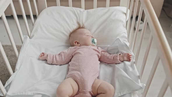 Newborn Girl Sleeping in Crib