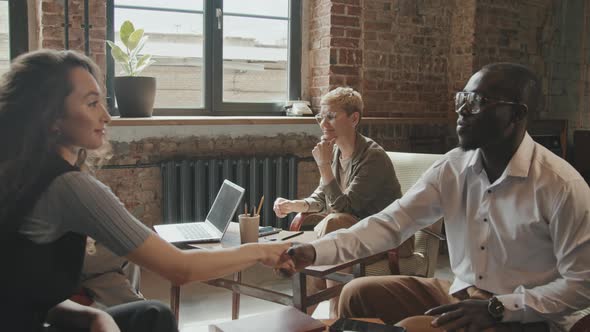 Cheerful Multi-Ethnic Business Partners Shaking Hands