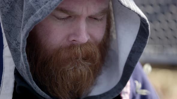 Close up of hairy mans face wearing hoodie