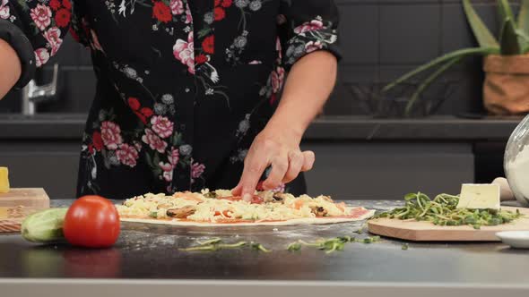 Female cooking pizza at home in modern kitchen.