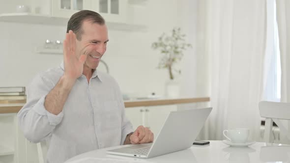 Middle Aged Man Doing Video Call on Laptop at Home