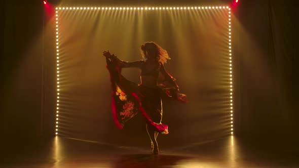 Silhouette of a Slender Attractive Girl Dancing in a Gypsy Costume. The Girl Is Whirling in a Dance