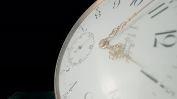 Antique Pocket Watch with a White Dial and Gold Moving Hands on Black Isolated Studio Background