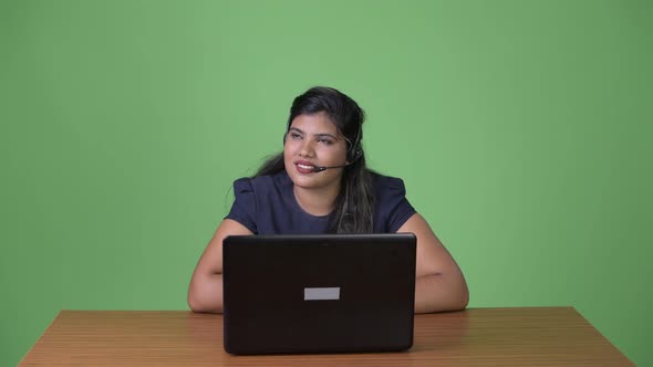 Young Overweight Beautiful Indian Businesswoman Against Green Background