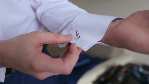 Man Buttoning Cuff Link on the Shirt Closeup