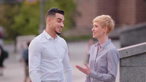 Two Friendly Multiracial Colleagues Arabic Spaniard Hispanic Man and Caucasian Woman Business