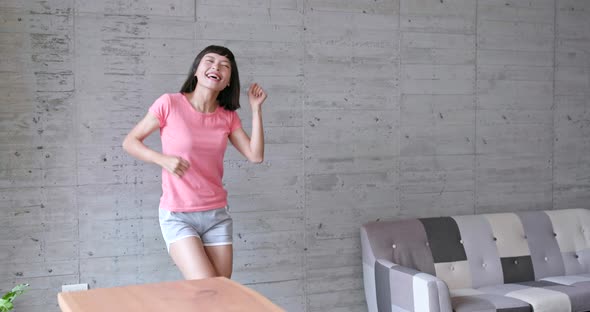 Young asian woman feeling happy and dancing at home