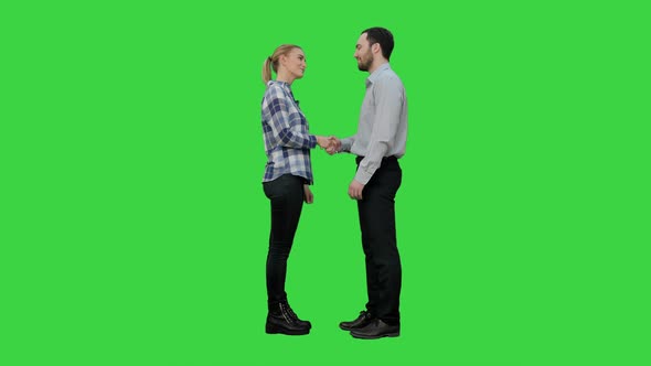 Two Young People Shake Hands Keep Silent on a Green Screen, Chroma Key