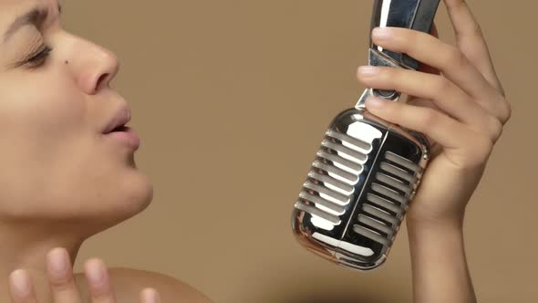 Beauty Portrait of Young African American Woman Singing Song Into Vintage Retro Microphone