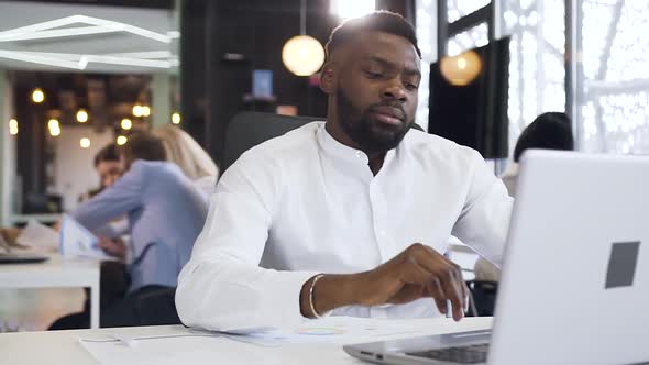 Dissappointed Dark-Skinned Bearded Businessman Seriously Looking at the Computer