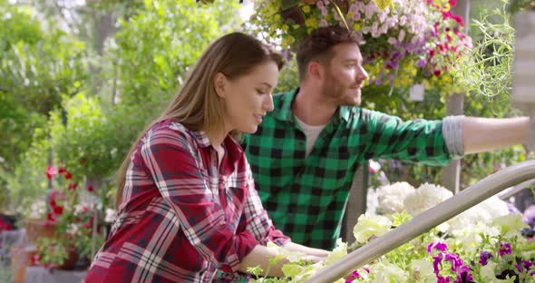 Professional Male and Female Gardeners Working with Flowers in Garden