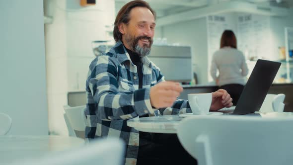 Adult Senior Man Work Remotely on Laptop at Cafe