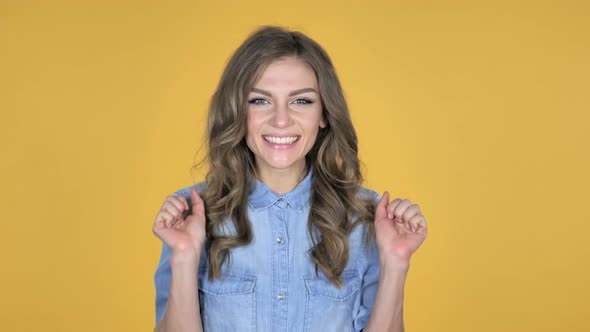 Happy Amazed Young Girl Surprised By Gift Isolated on Yellow Background