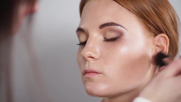 Close Up Shot of a Make-up Artist's Hands, Who Is Applying Powder with Mascara