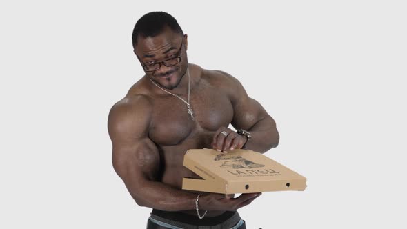 Athletic handsome naked body of african man with pizza