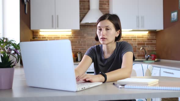 Focused Woman Working on Laptop Computer in Home Office
