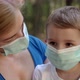 Mother Hugs Her Son in Medical Masks While Sitting in a Park - VideoHive Item for Sale