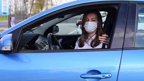 Woman in Protective Mask in Car